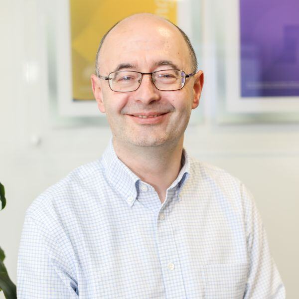 A man in a shirt stood in front of a wall